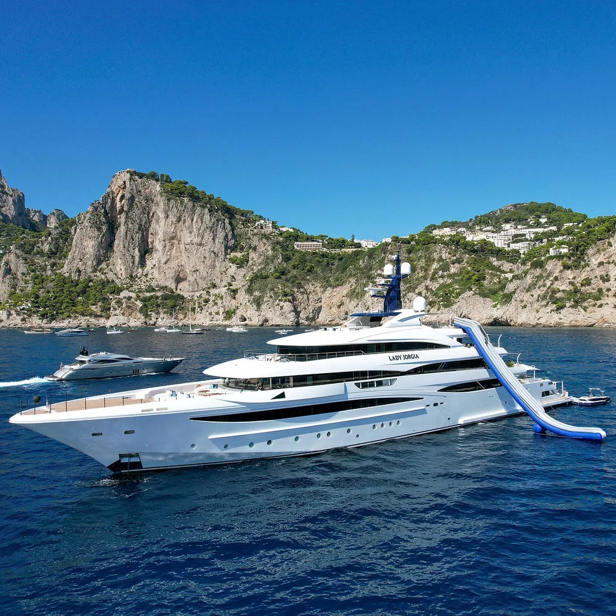 Yacht Lady Jorgia avec toboggan bleu et blanc devant falaises de Capri